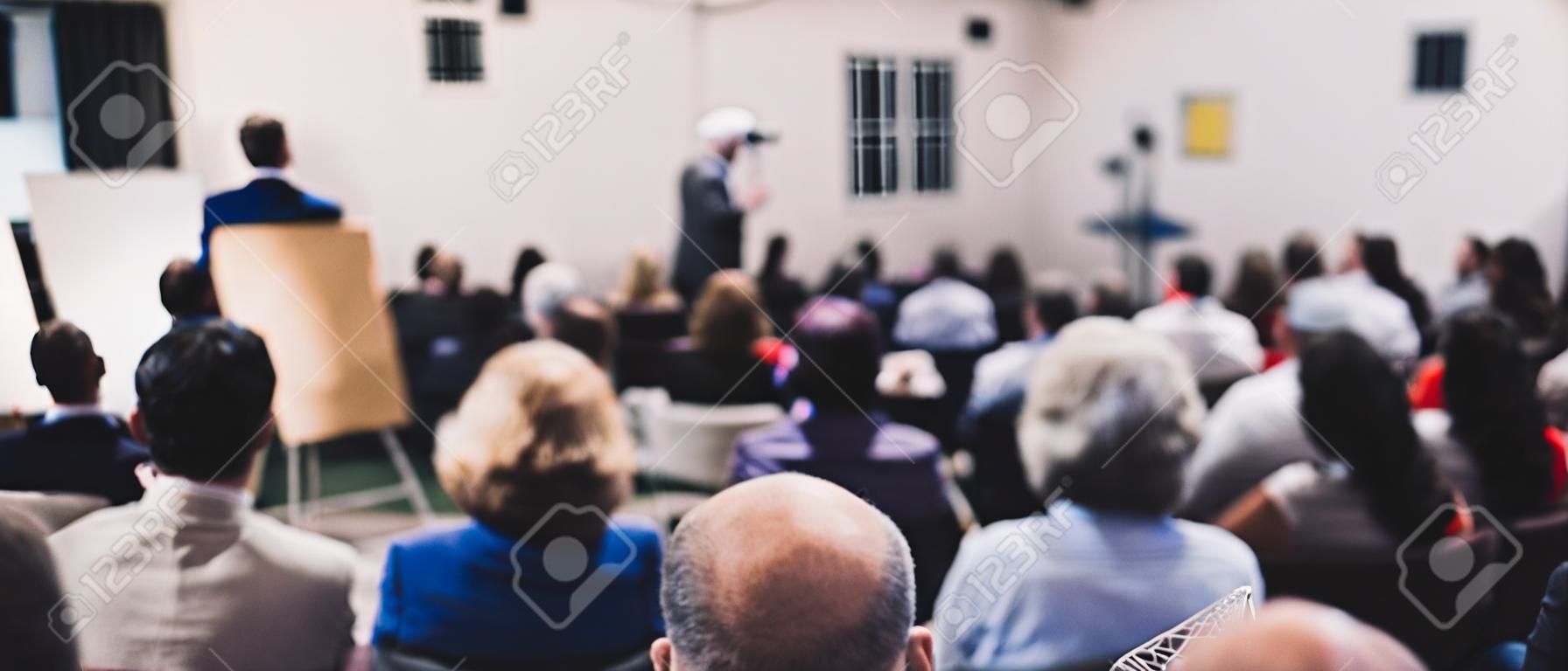 Simposio de empresa y emprendimiento. orador dando una charla en una reunión de negocios. audiencia en la sala de conferencias. vista trasera de un participante no reconocido en la audiencia.