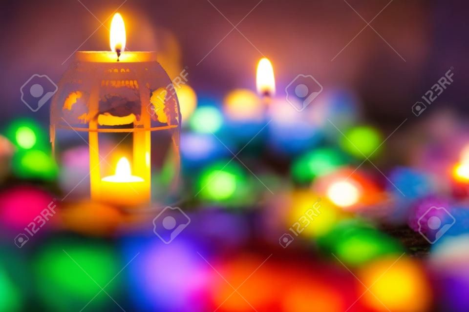 Płonące świece, kolorowe kwiaty i świąteczne dekoracje na grobach na cmentarzu