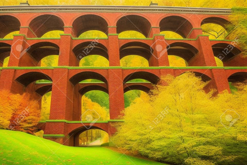Magnífica ponte enorme em um belo parque verde. o viaduto goltzsch é o maior viaduto de tijolo vermelho do mundo. manhã fria e ensolarada em outubro. alemanha.