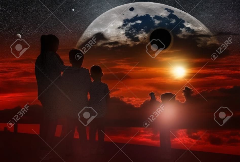 Erstaunliches wissenschaftliches Naturphänomen. Der Mond bedeckt die Sonne. Silhouette von Mutter und Kindern, die die totale Sonnenfinsternis mit Diamantringeffekt am Himmel betrachten. Glückliche Familie, die Zeit zusammen verbringt.