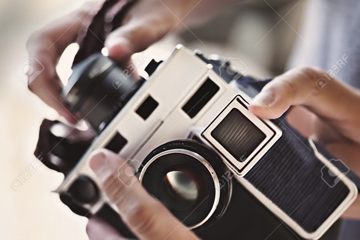 Hand met filmcamera, oude retro camera op vintage concept.