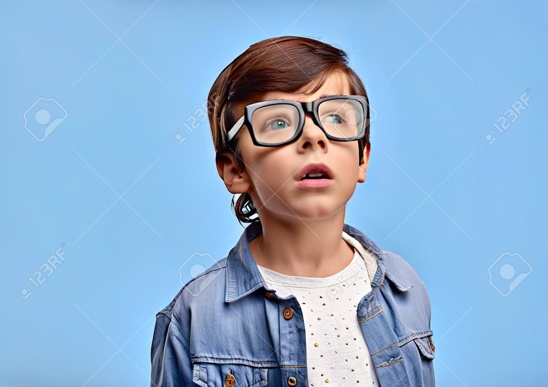 Entzückender neugieriger Junge in Brillen