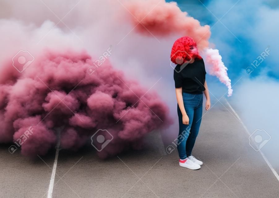 Stylowy nastolatek stojący w pobliżu bomby dymnej w mieście