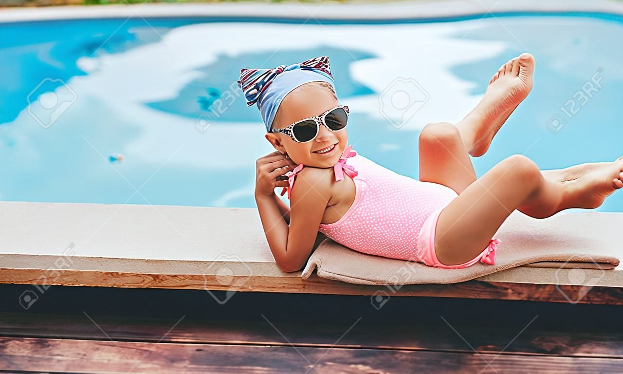 Barefoot girl lounging near pool