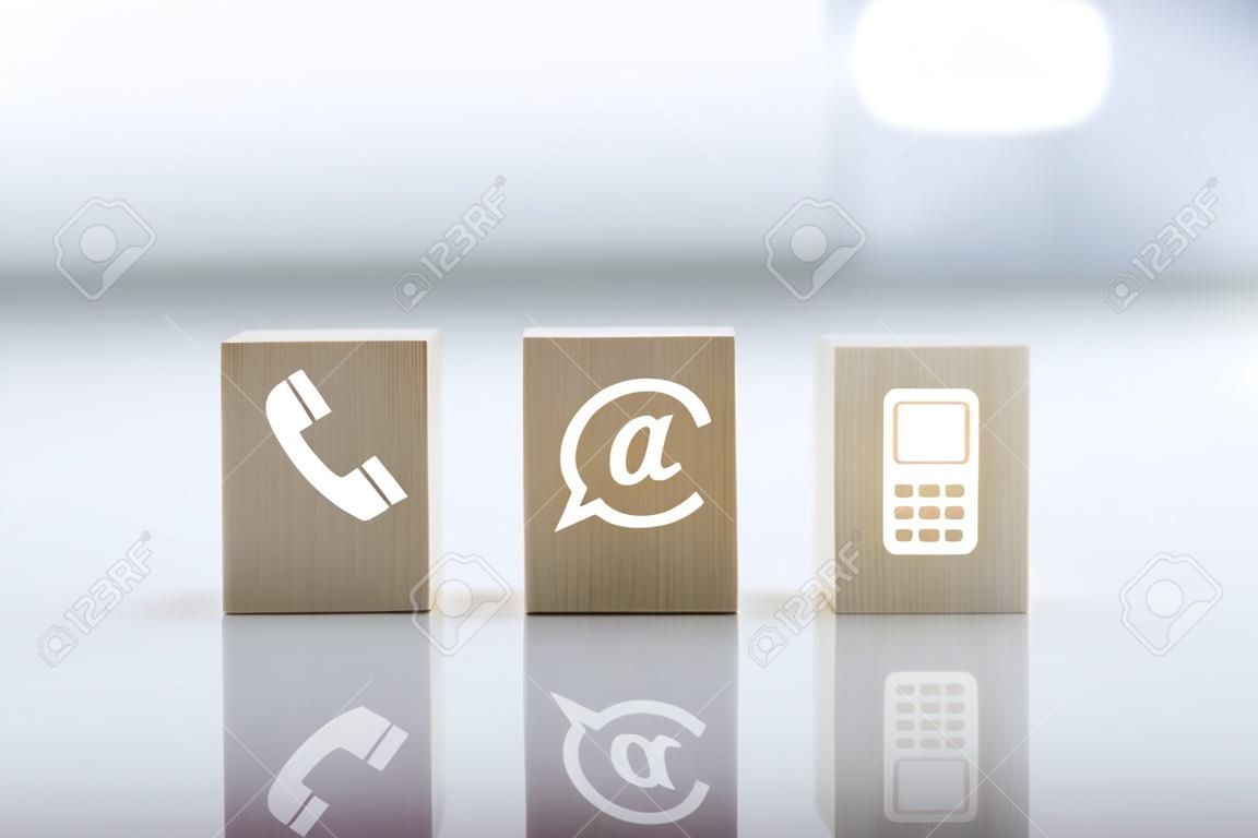 Contattaci concetto con telefono simbolo blocco di legno, posta, indirizzo e telefono cellulare. Pagina del sito web contattaci o e-mail marketing concept