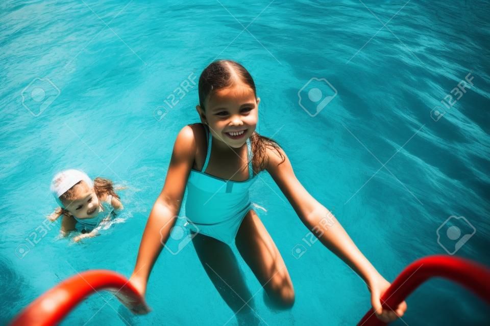 Kleines Mädchen steigt mit Leiter aus dem Wasser