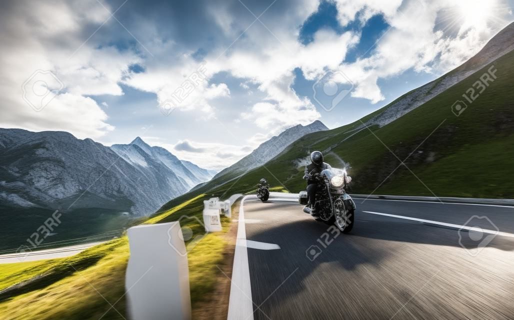 Motorista que monta na estrada alpina na famosa Hochalpenstrasse, Áustria, Europa central.
