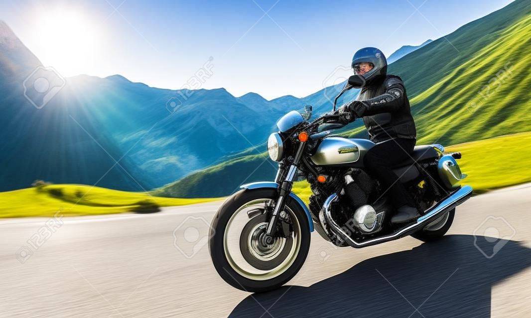 Kierowca motocykla jedzie na autostradzie alpejskiej, Nockalmstrasse, Austria, Europa.