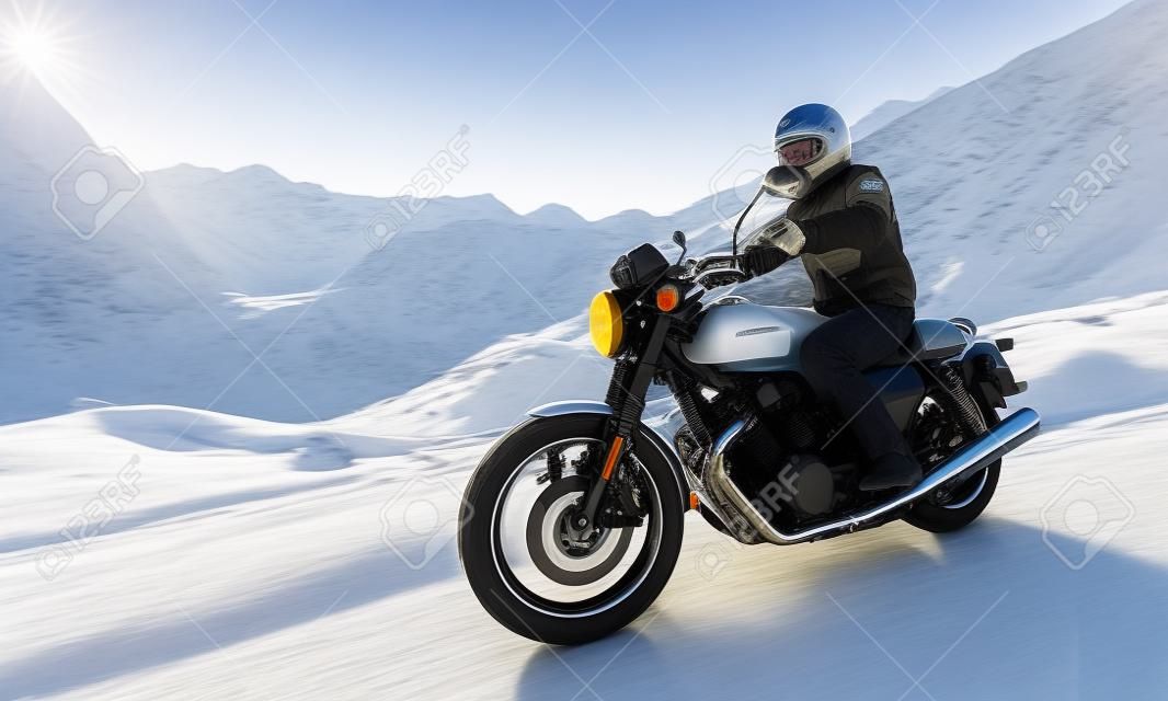 Motorcycle driver riding in Alpine highway, Nockalmstrasse, Austria, Europe.