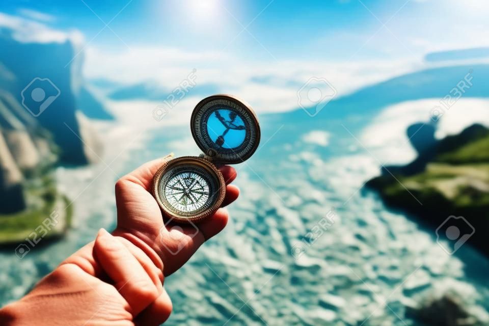 Beautiful landscape with old compass on traveler's hand. Traveling concept.