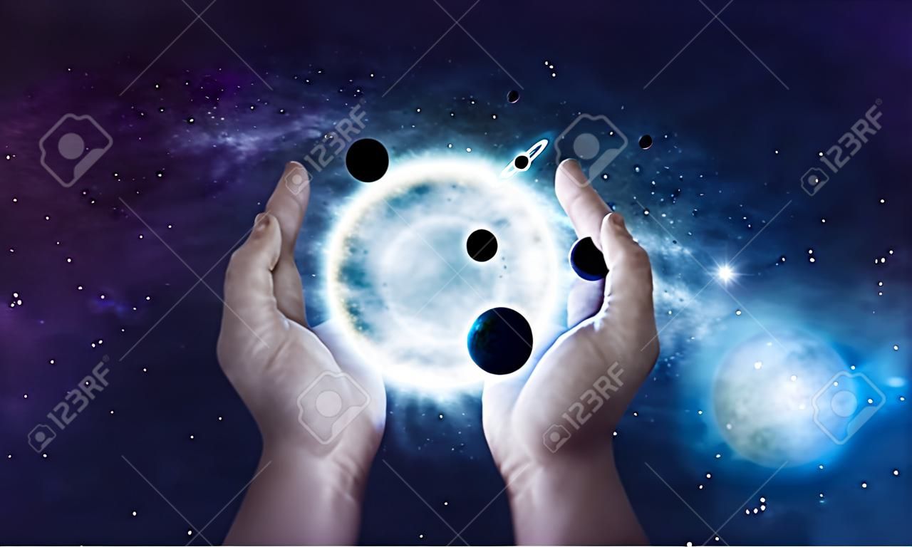 Dos manos que sostienen el sol y los planetas en el universo