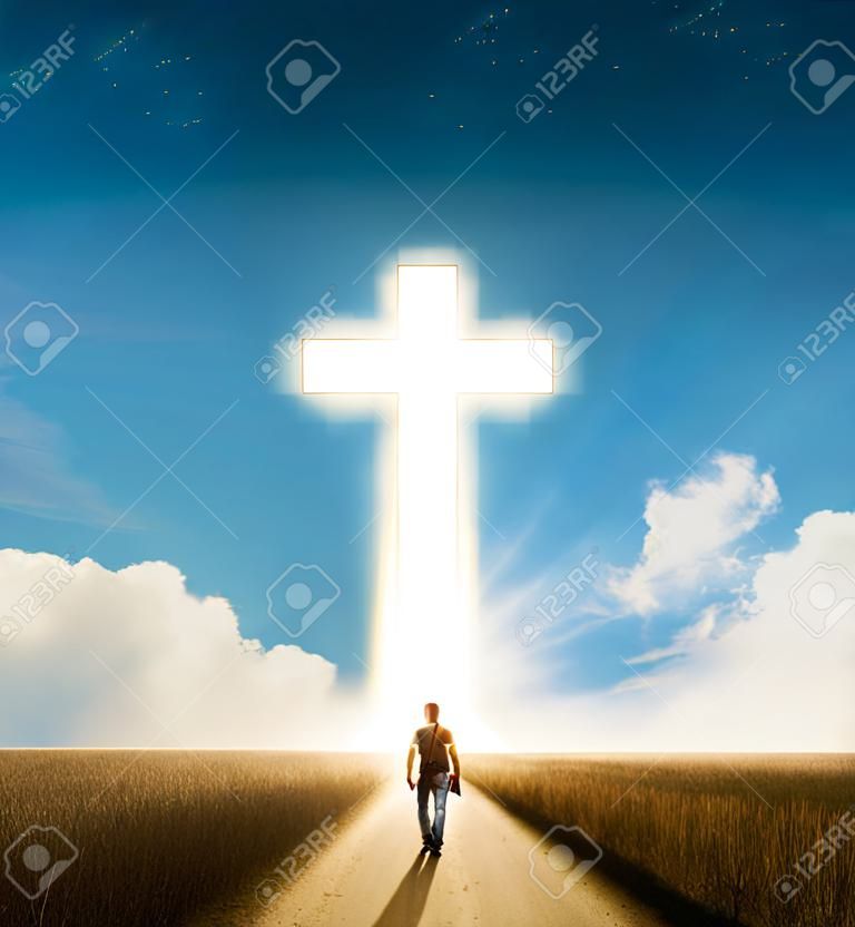 Een man die naar een groot gloeiend christelijk kruis loopt