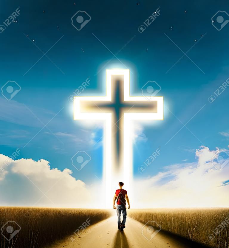 Człowiek pieszo w kierunku dużego świecącego krzyża chrześcijańskiego