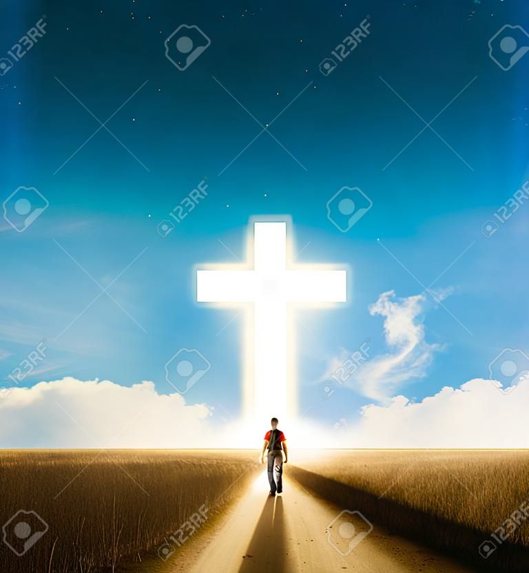 A man walking towards a large glowing Christian cross