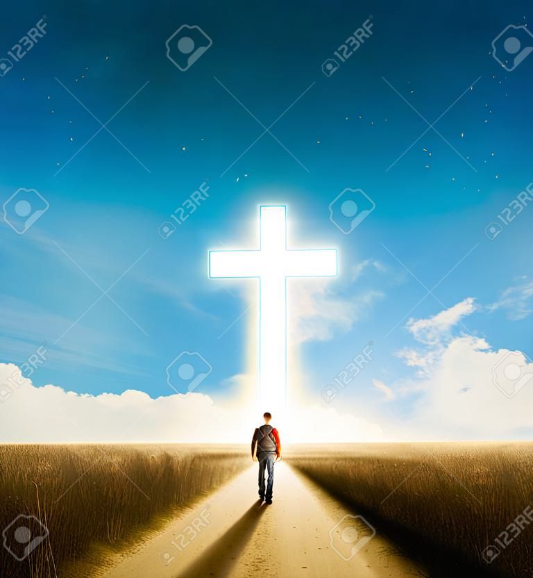 Een man die naar een groot gloeiend christelijk kruis loopt