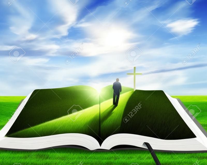 A nyitott biblia fű és egy férfi sétált felé, egy kereszt