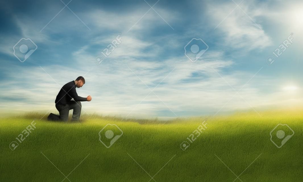 男子跪在一個領域祈禱