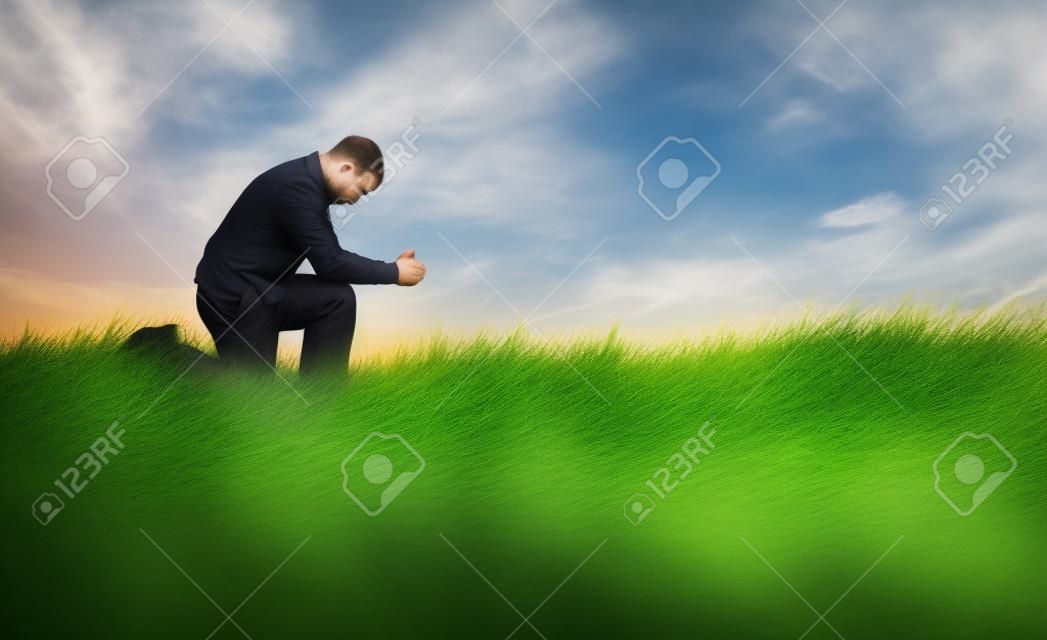 男子祈禱在草地