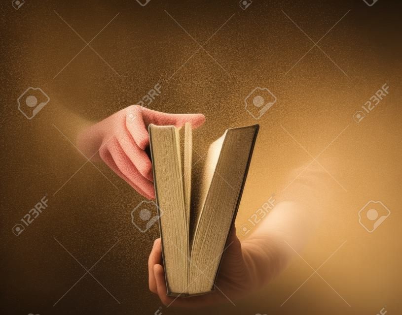 Holding an open book with dust coming out 
