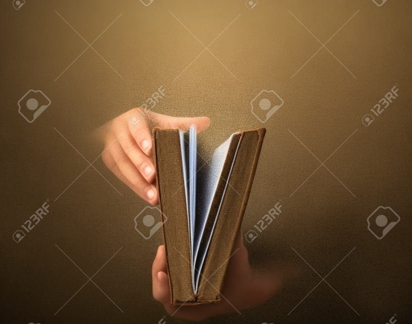 Segurando um livro aberto com poeira saindo