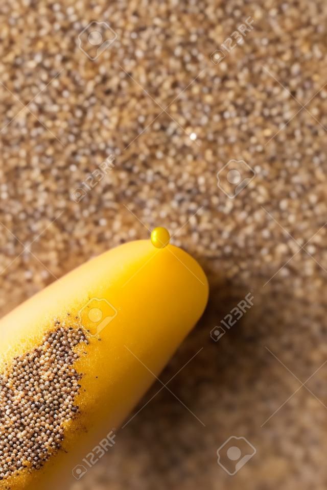 A single mustard seed resting on the tip of a finger.