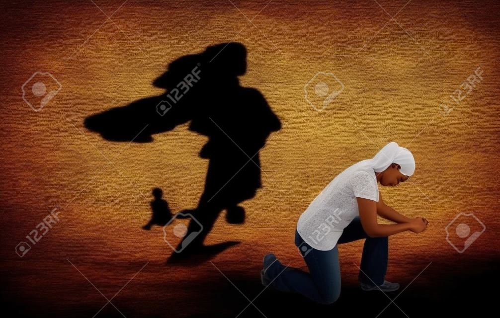 Eine Frau betet während ihr Schatten, ein Superheld ist.