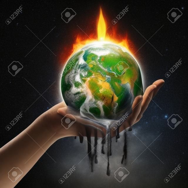 A hand holds up an Earth that is melting from the fire.