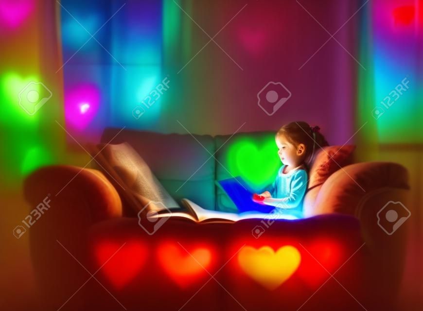 A little girl reading alone with a color heart glowing out of the pages