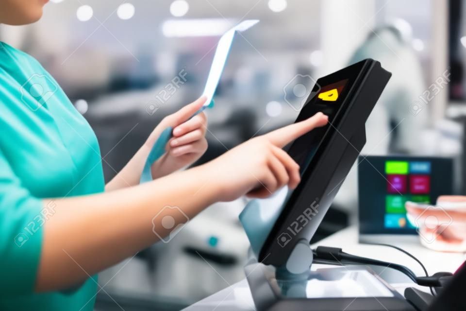 Jeune femme mains scannant, entrant dans une remise, vente sur un reçu, caisse enregistreuse à écran tactile