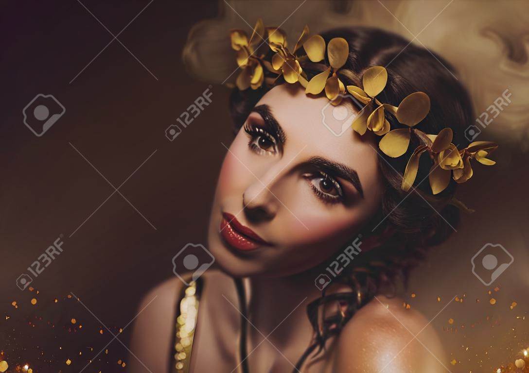 Ritratto del primo piano Ragazza con trucco creativo e con ciglia dorate. La dea greca in una corona di alloro con fiori e rose fatte a mano. Foto d'arte