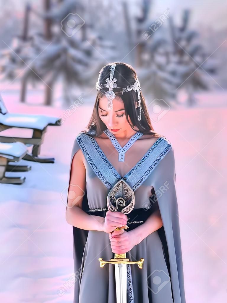 charming sweet dark-haired girl with closed eyes reads prayer to gods of war before terrible fight, elegant princess holds silver sword, meditation with weapon for hardening spirit of warrior