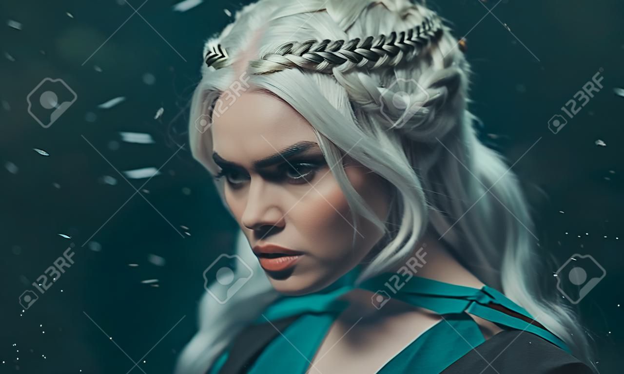 Porträt eines blonden Mädchens hautnah. Hintergrund dunkel mit fliegendem Schnee, Asche. Weißes Haar mit kreativem Flechten. Gefühle von Wut und Wahnsinn. Die Gothic-Königin in einer tiefen Winternacht. Kunstfoto