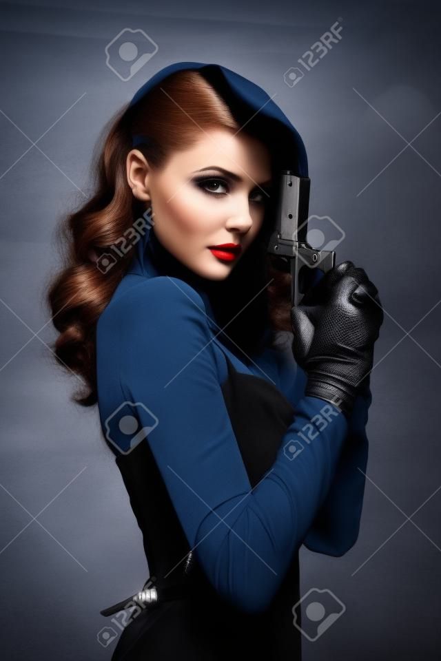 Beautiful dangerous woman spy holding pistol in her hands. retro girl with elegant evening hairstyle, beautiful face. Fashion model with gun, weapon. image of detective in undercover investigation