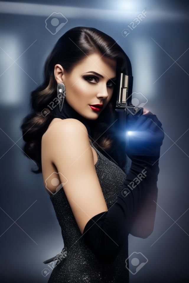 Beautiful dangerous woman spy holding pistol in her hands. retro girl with elegant evening hairstyle, beautiful face. Fashion model with gun, weapon. image of detective in undercover investigation