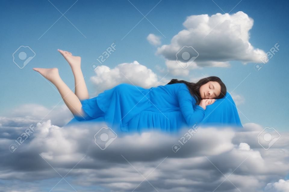 Fille décontractée en robe à volants lévitant dans les airs, dormant sur le ventre allongé confortablement sur un oreiller, gardant les yeux fermés, regardant un rêve paisible. composition de collage le jour ciel bleu nuageux