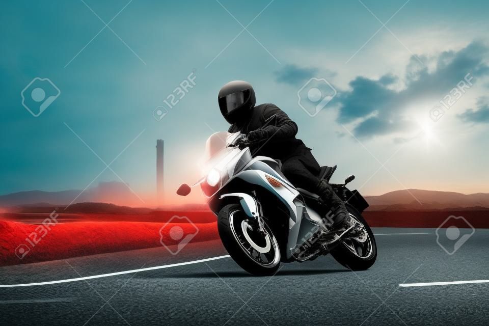 young man riding sport touring motorcycle on asphalt highways against beautiful lighting of urban industry scene use as modern people lifestyle and holiday activities
