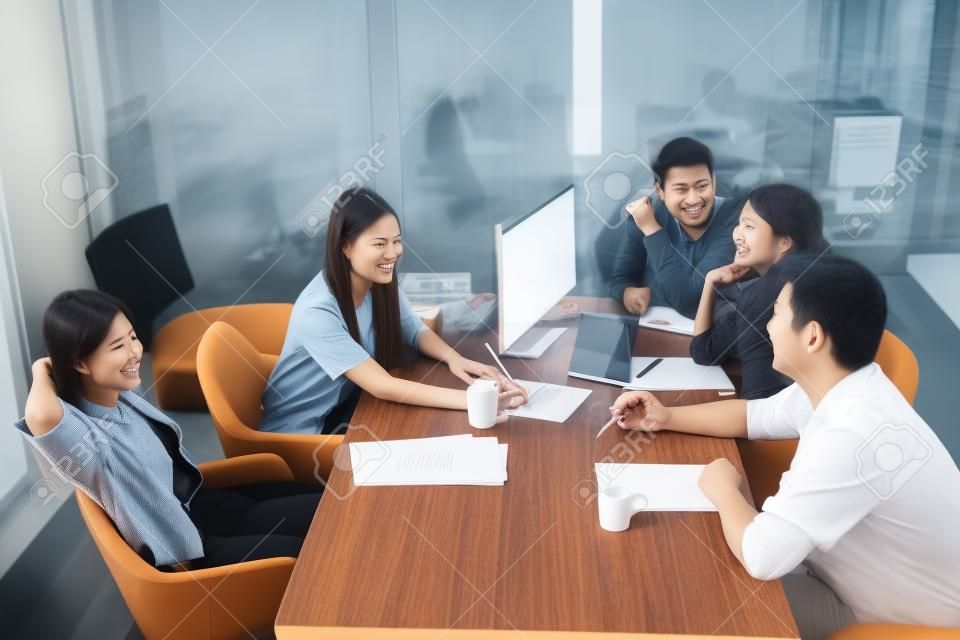 jong aziatisch freelance team ontspannen op werktafel in kantoor vergaderruimte