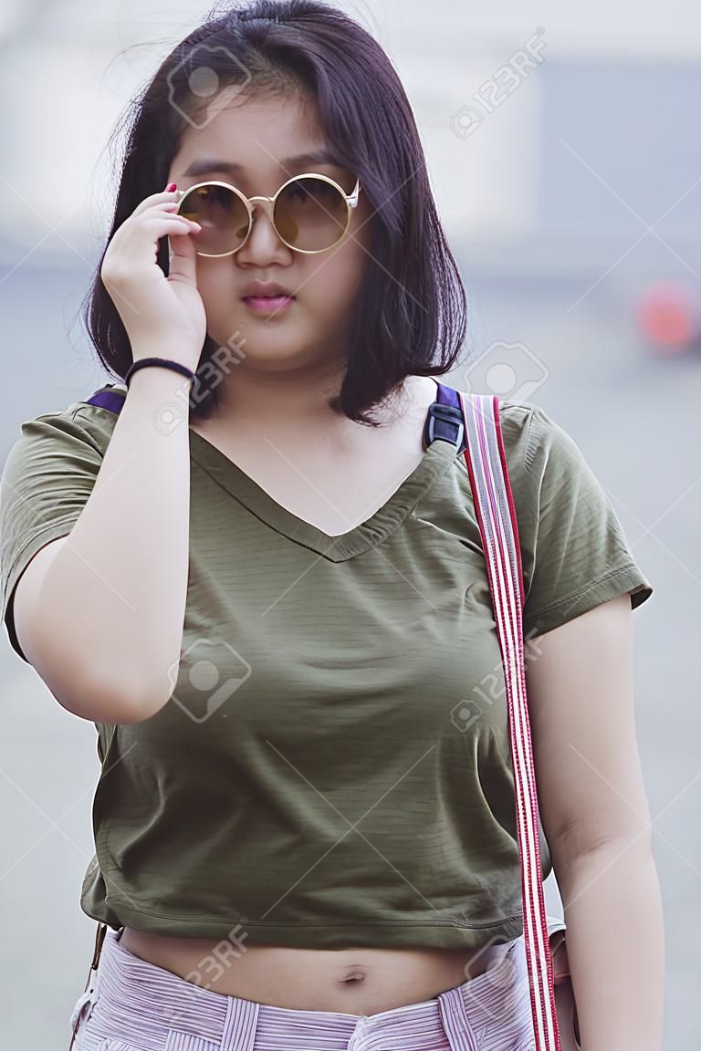 adolescent asiatique portant des lunettes de soleil debout avec confiance en soi