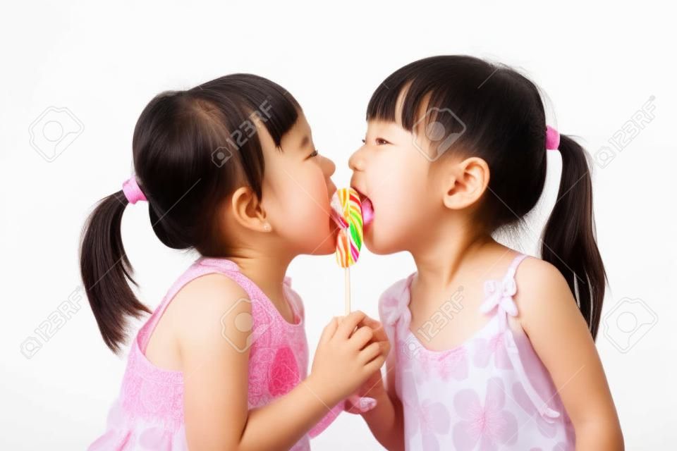 Asian Little Chinese girls eating lollipop in isolated white background