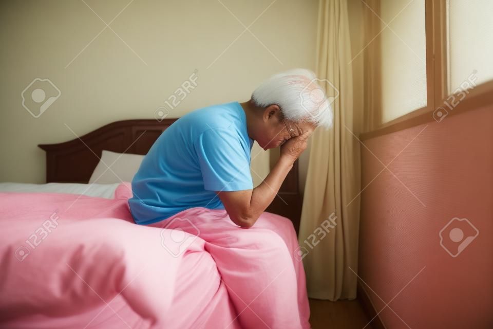 Starszy azjatycki mężczyzna w sypialni.