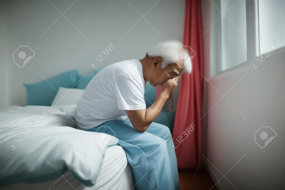 Starszy azjatycki mężczyzna w sypialni.