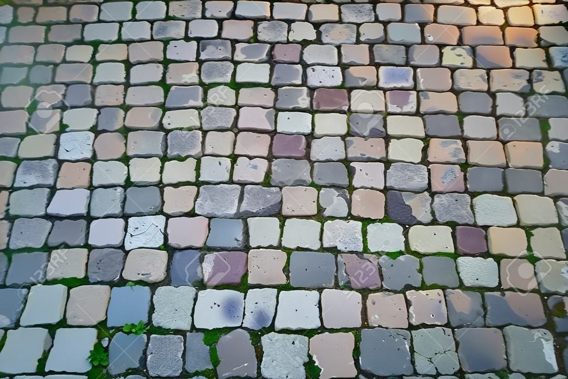 El fondo está hecho de viejos adoquines en la parte antigua de la ciudad, la textura de la piedra