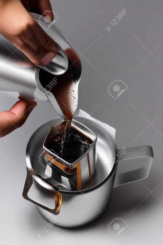 Hand pouring hot water to Drip bag fresh coffee