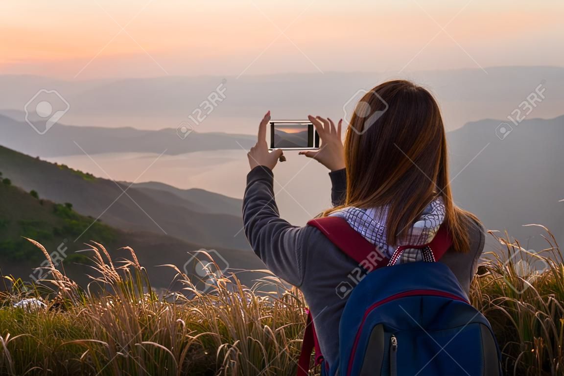 Young traveler taking photo beautiful landscape sunset