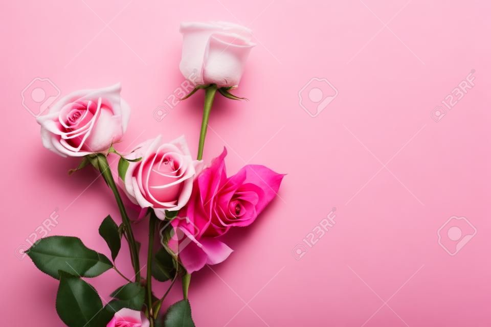 A bouquet of hybrid tea roses and floribunda on a pink background.