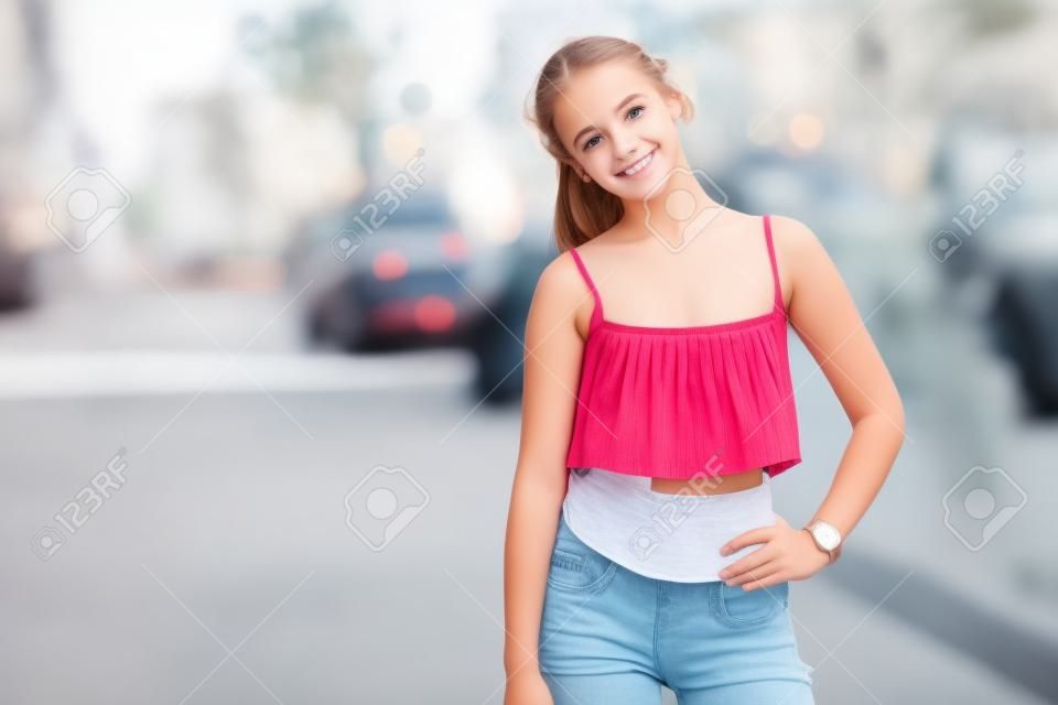 Симпатичные подростковой девушка с верхней стоит на улице