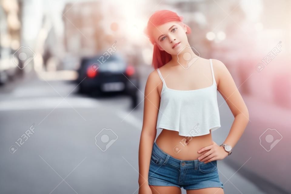 Симпатичные подростковой девушка с верхней стоит на улице