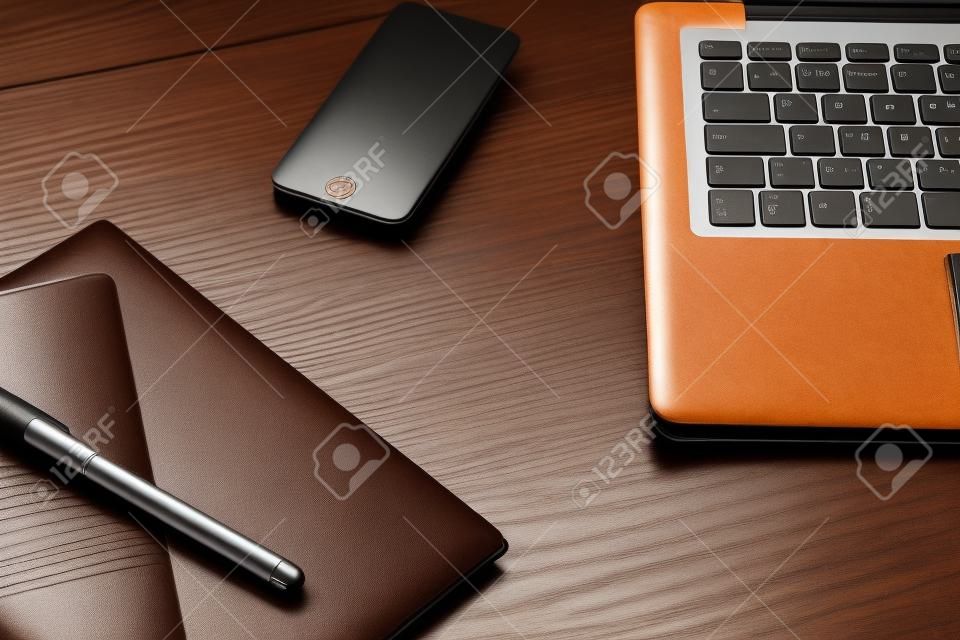 Teclado del ordenador portátil y el diario en el escritorio de madera marrón