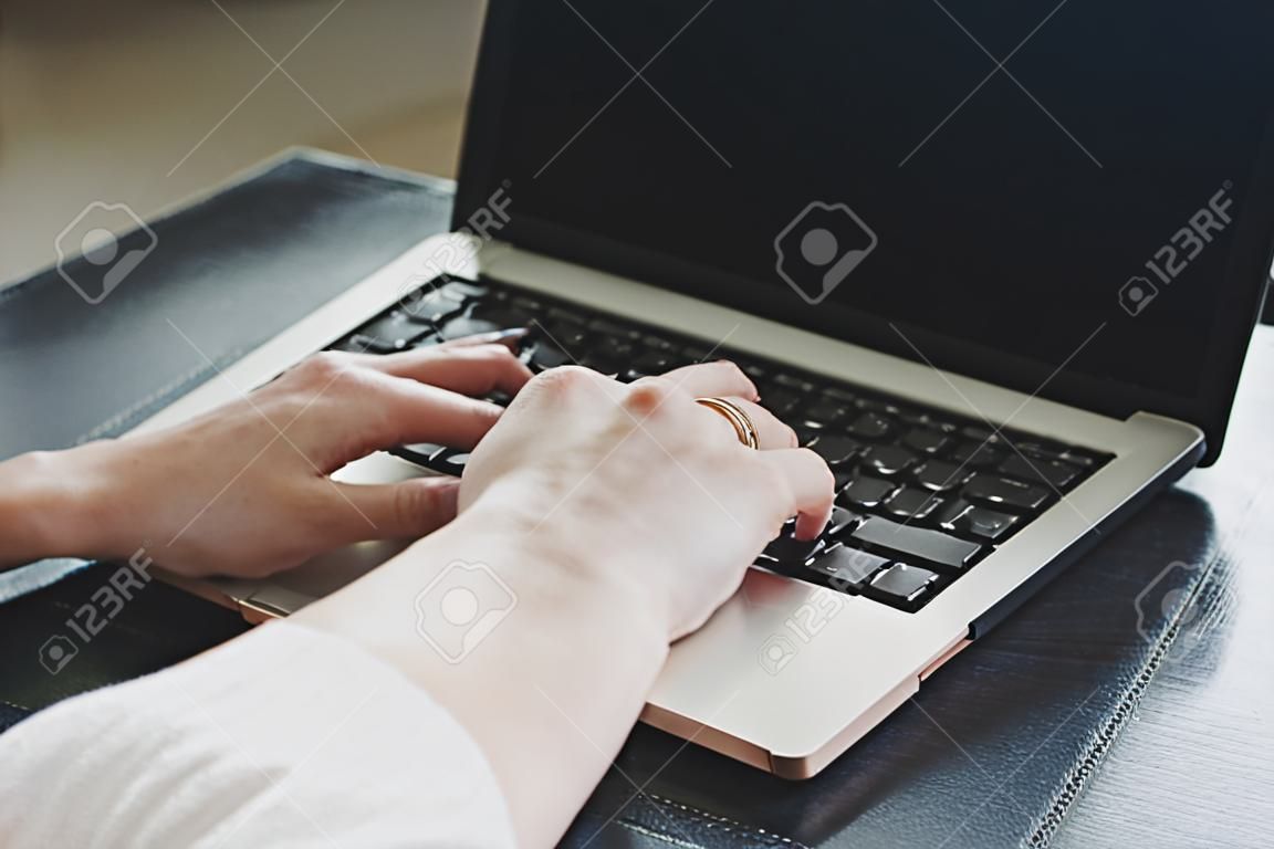 Woman working with laptop placed on the black desk