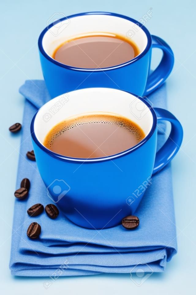 due tazze di caffè con tovagliolo blu